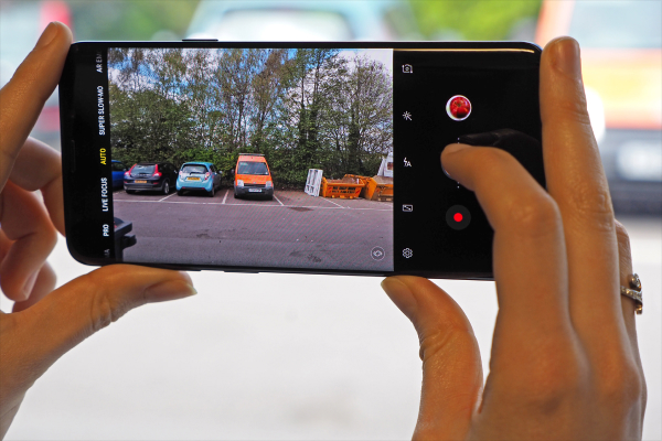 Smartphone taking a high-quality photo, while a traditional digital camera sits unused in the background.
