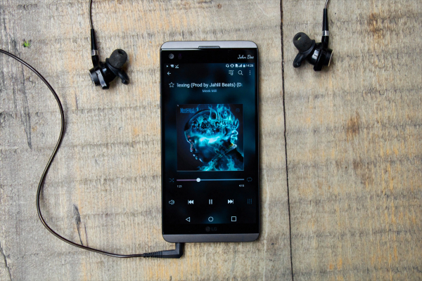 Smartphone playing music through a streaming app, replacing an old MP3 player like an iPod.
